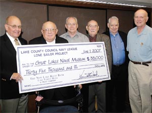 A $35,000 check is presented to Carl Ross, (left), president of the Great Lakes Naval Museum Association, by Pat Gallagher, president of the Lake County Navy League Council and Navy League members George Greene, Don Rudny, Ken Woods and Tom Doddington.